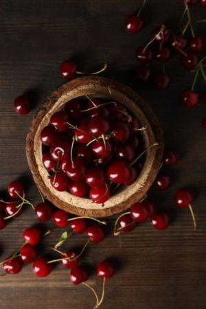 Ripe cherry fruits in a bowl on a wooden background