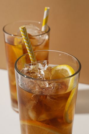 Glasses of cold tea with an orange