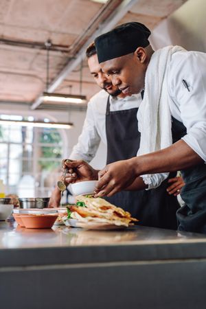 Two professional cooks working at restaurant kitchen together