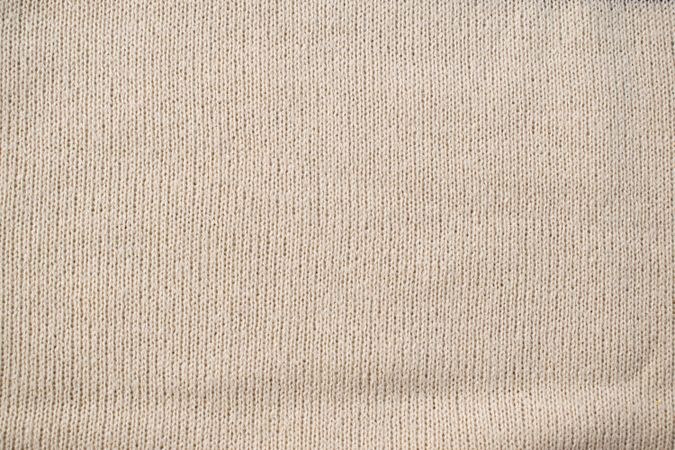 Detailed cream or vanilla knitted fabric background texture.