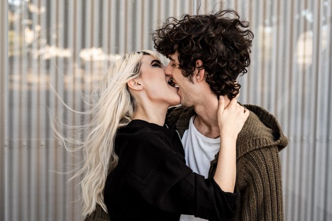 Happy loving couple having fun while kissing on street
