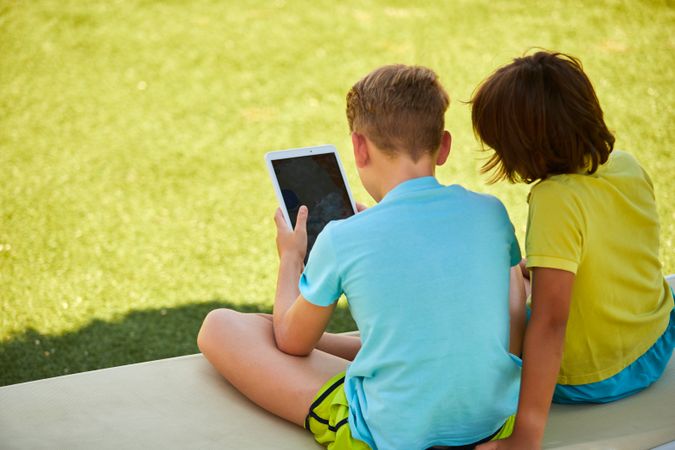 Boys using tablet in garden