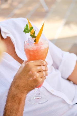 Unrecognizable man holding cocktail glass in hand