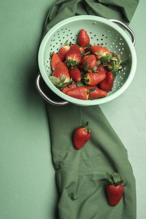 Ripe strawberries in a rustic colander