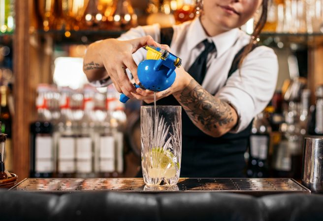 Female bartender preparing a cocktail in a traditional cocktail bar