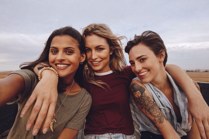 Beautiful women taking selfie while traveling by a pickup truck