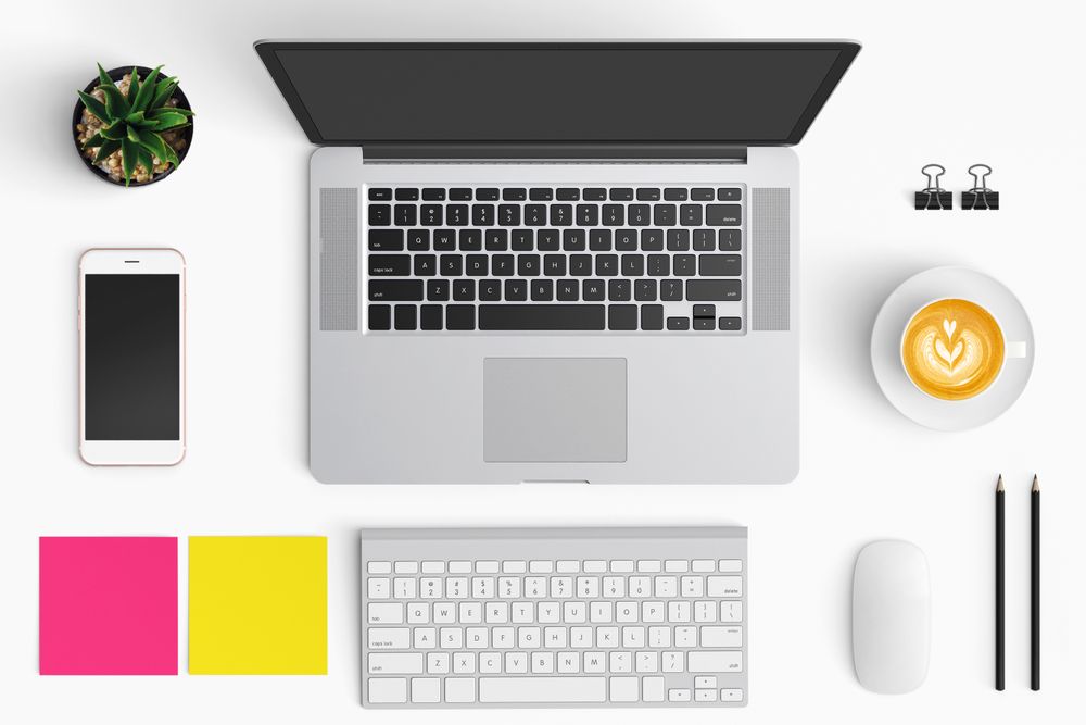 Modern workspace with coffee cup, smartphone, paper, notebook, tablet and laptop copy space