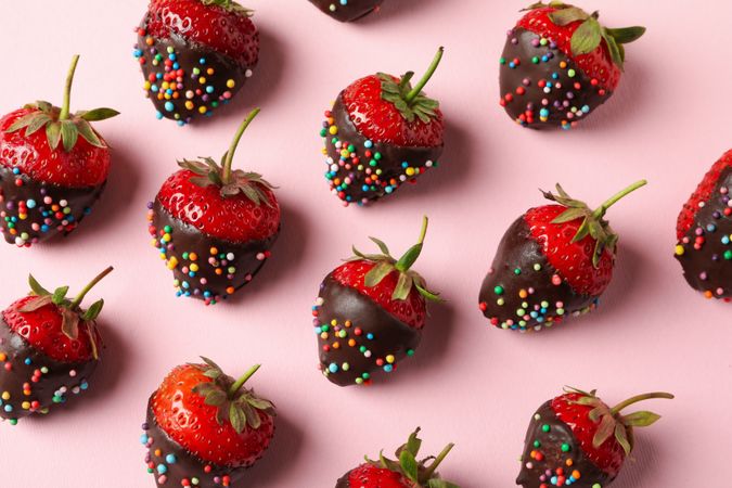 Chocolate fondue. Flat lay with strawberry in chocolate on pink background