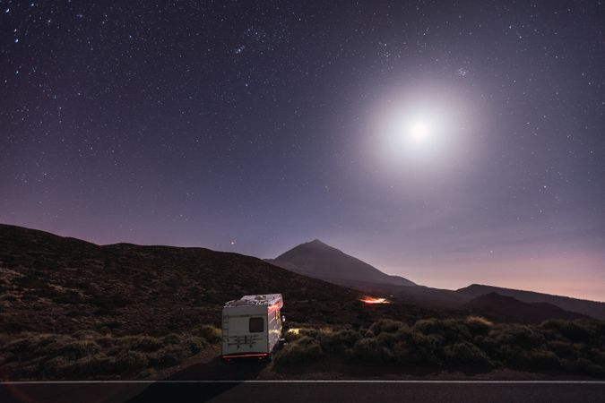 Traveling caravan in desert with bright moon