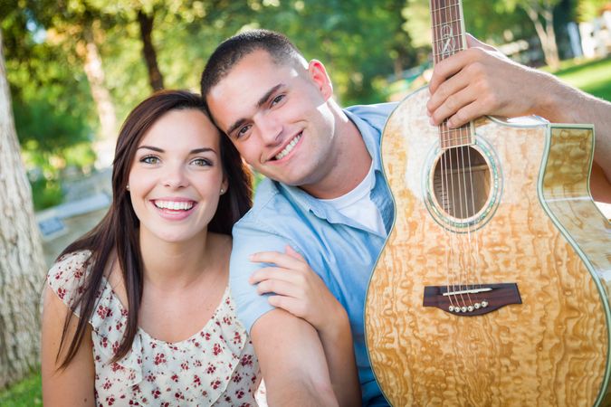 Young Adult Couple Portrait with Guitar in the Park.