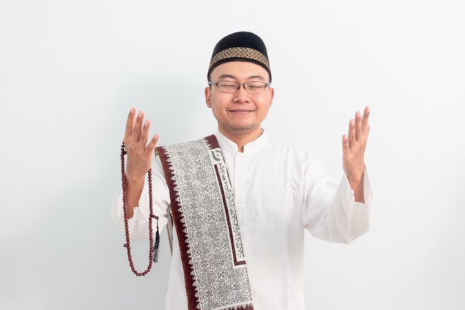 Asian Muslim man smiling doing greeting pose during Ramadan