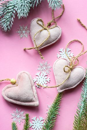 Christmas decorations and felt hearts on pink background