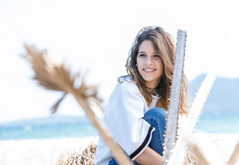 Young woman sitting near dried plants