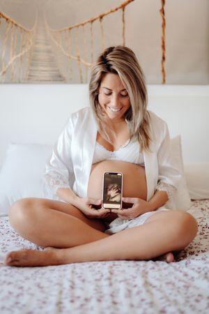 Faceless pregnant woman showing picture from ultrasound scan