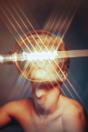 Blurry light over topless young man's face