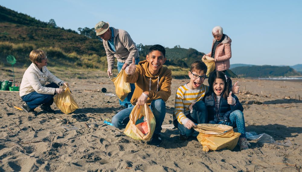 Young man and children cleaning the beach