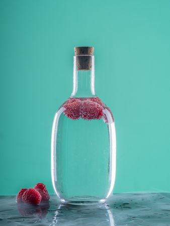 Bottle with drink near berries