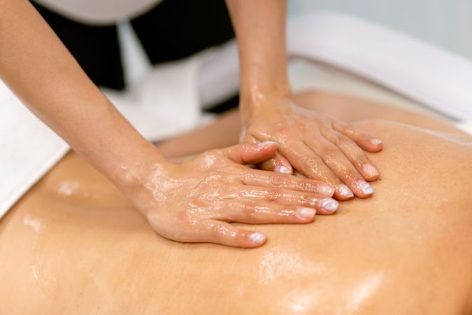 Masseuse giving an oily massage to a client