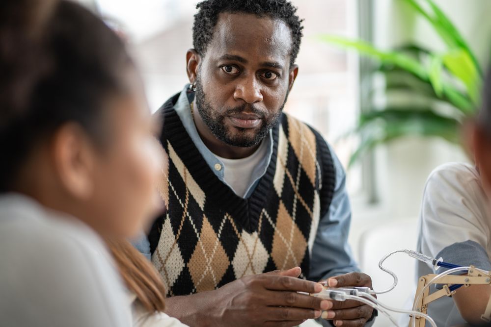 Male teacher listening to student’s questions in class