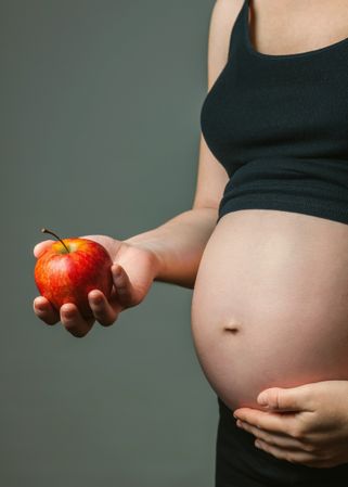Pregnant woman holding an apple