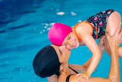 Mother playing with daughter in swimming pool