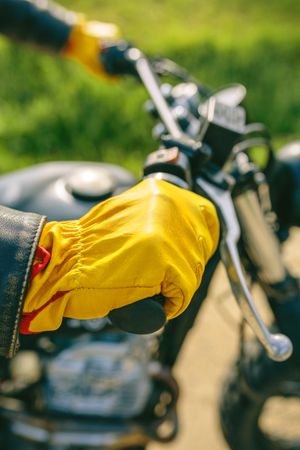 Biker's hand with gloves grabbing the handlebar