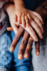 Hands of father, mother, and baby
