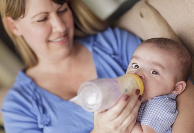 Happy Mother Bottle Feeding Her Son