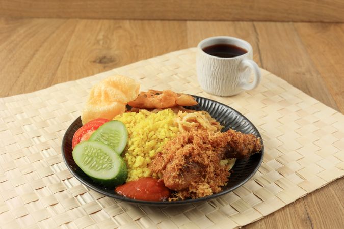 Nasi kuning yellow rice with tumeric, vegetable, and chicken