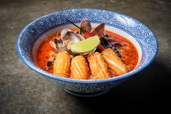 Typical hot ramen dish with fish broth in a bowl with noodles, squid, chilli, clams.