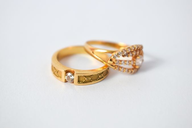 Two diamond gold rings on plain table