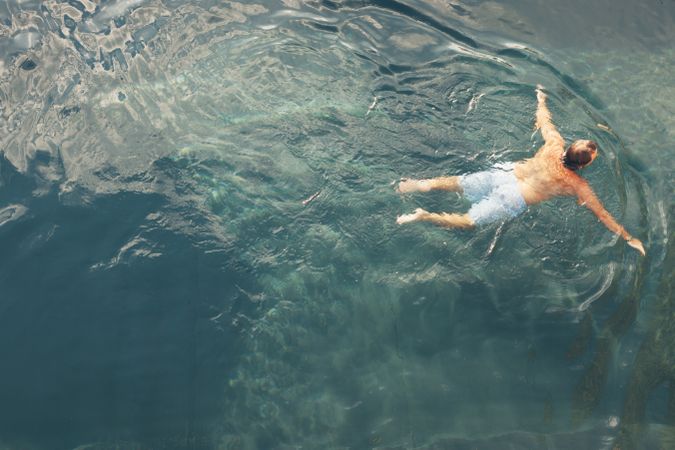 Man swimming in blue water