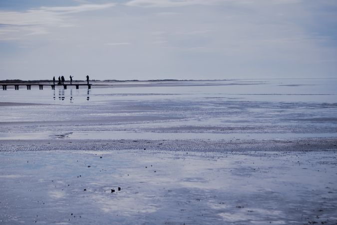 River delta with silhouettes of people standing on pier