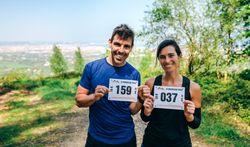 Man and woman showing their trail race number