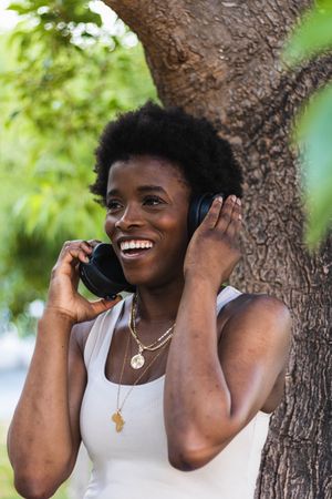 Excited Black woman listening to music in headphones
