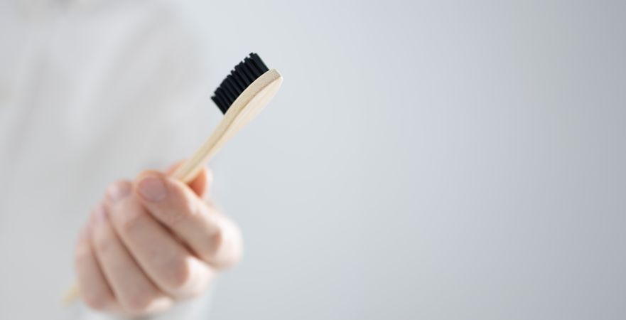 Man holding bamboo toothbrush