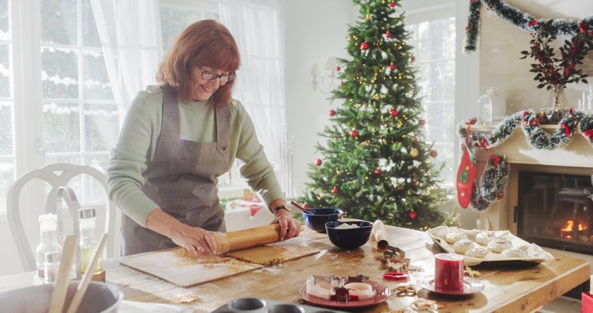 Portrait of Mature Female Preparing Dough for Making Gingerbread for Christmas at Home.