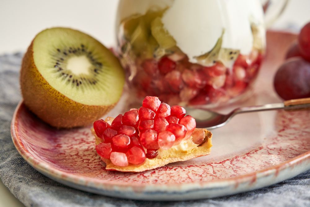 Delicious yogurt dessert with pomegranate, kiwi, grape and ginger biscuit
