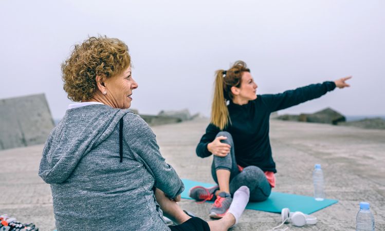 Mature sportswoman with woman pointing