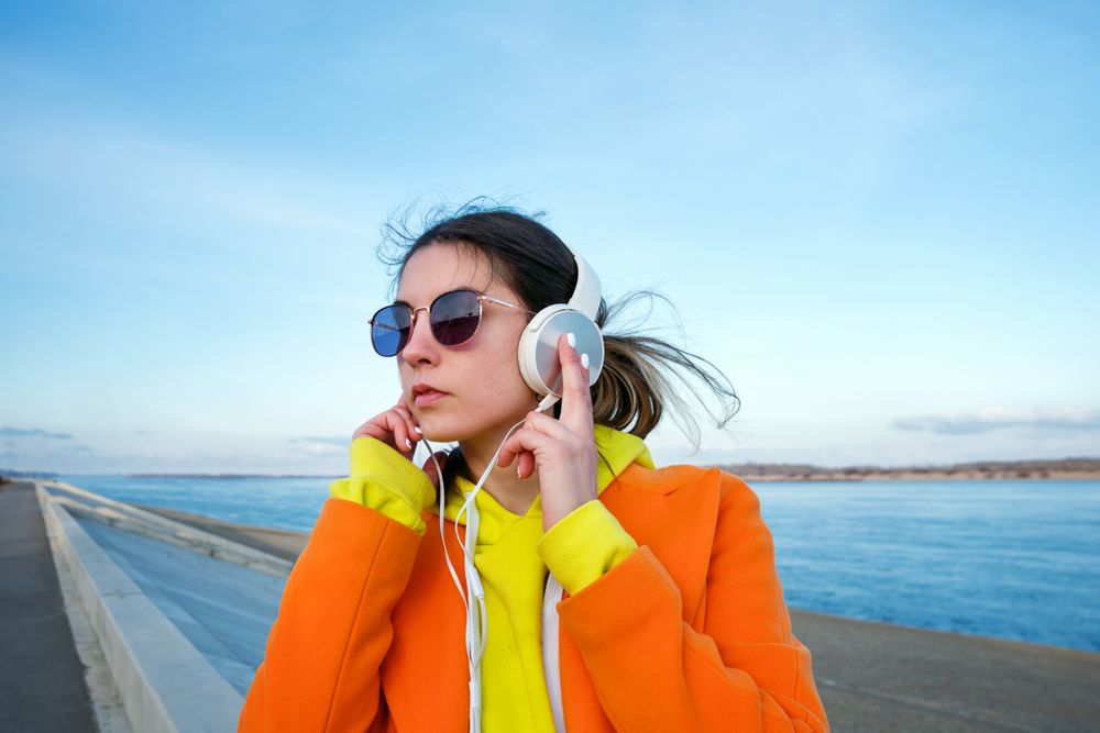 Woman with headphones on the beach