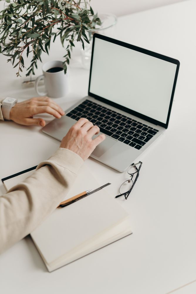 Person in beige long sleeve shirt using laptop