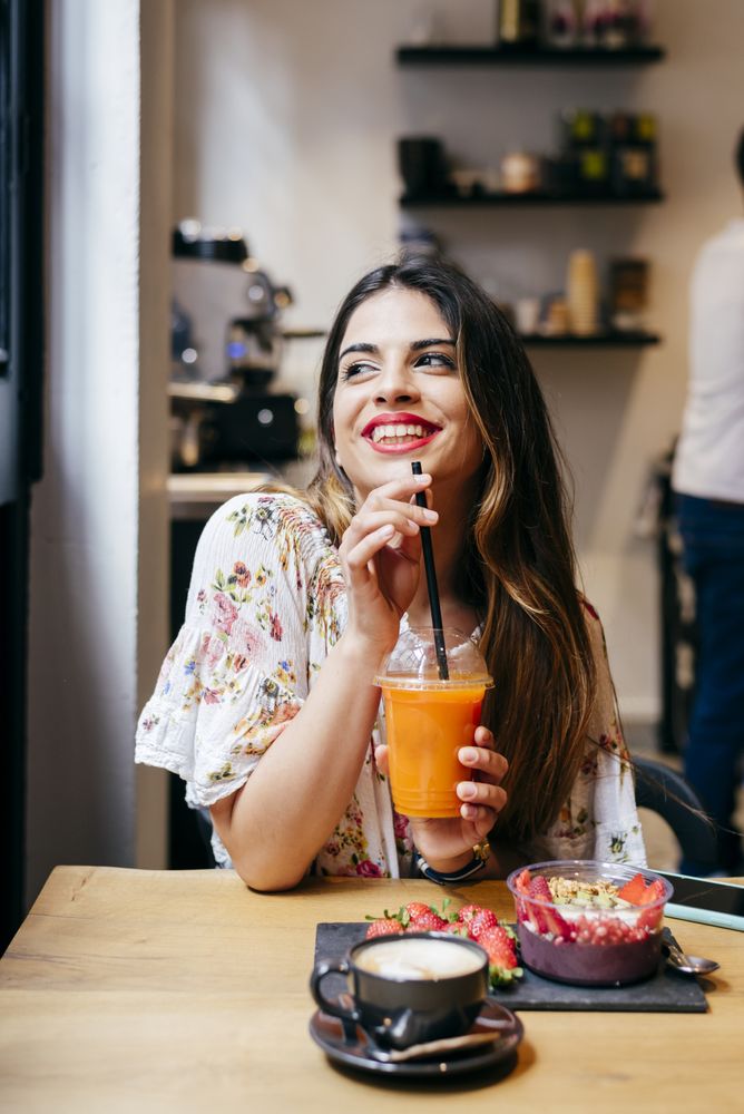 Woman enjoying smoothie at cafe
