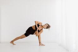Sportive woman performing yoga pose in room