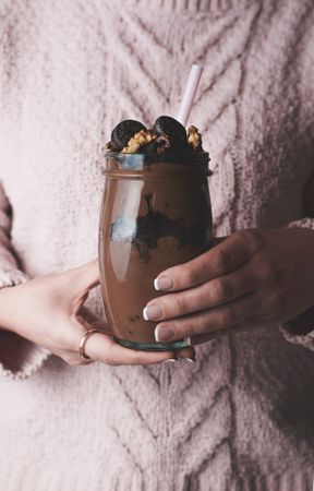 Crop woman with jar of chocolate mousse