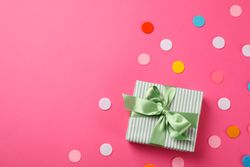 Gift box with bow on pink background, space for text