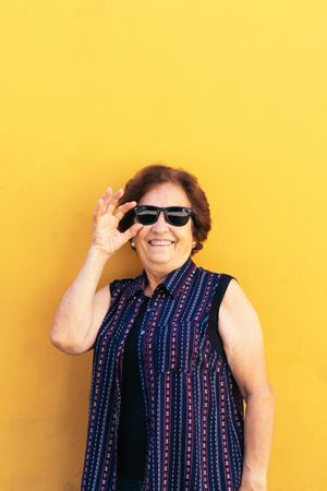 Stylish older woman in sunglasses and colorful clothes