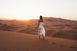 Woman in white dress walking in desert