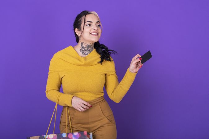 A women holding a shopping bag while showing a credit card. Shopping concept.