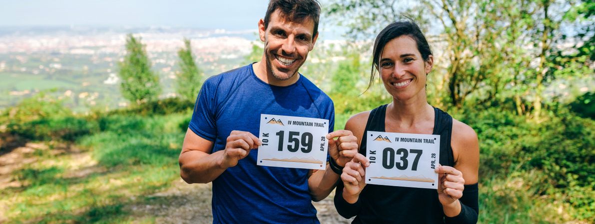 Man and woman showing their trail race number