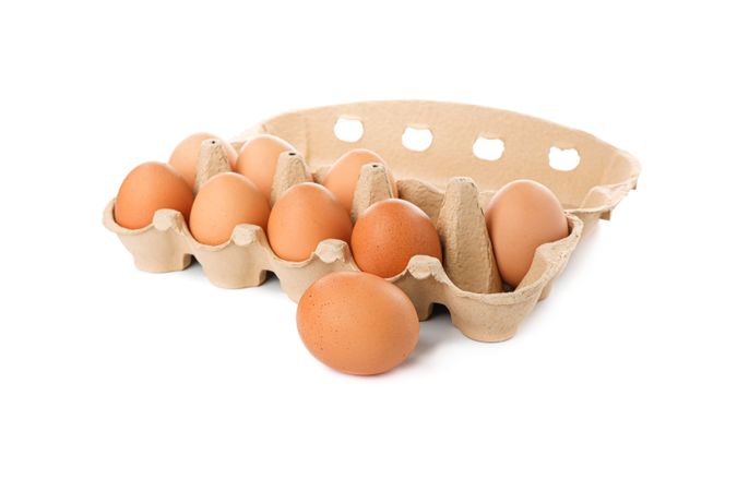 Brown chicken eggs in carton box isolated on plain background